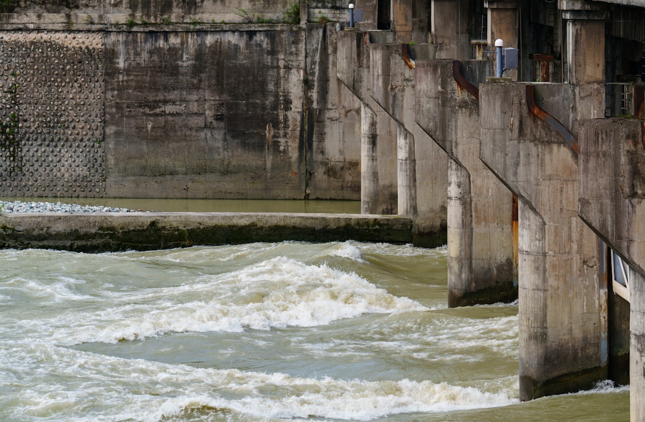 Turbulent water held and channelled by a row of concrete piers