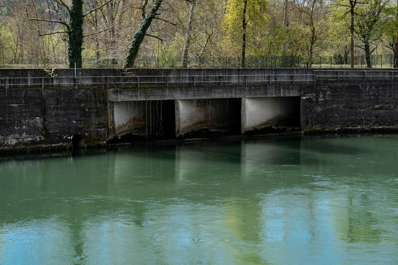Three concrete outfall openings discharging into the receiving water